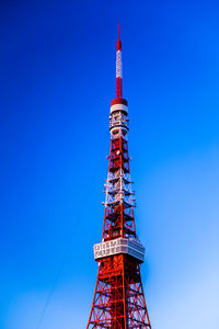 Low angle view of communications tower against blue sky