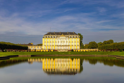 Reflection of buildings in lake against sky