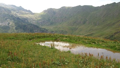 Scenic view of lake by mountains against sky