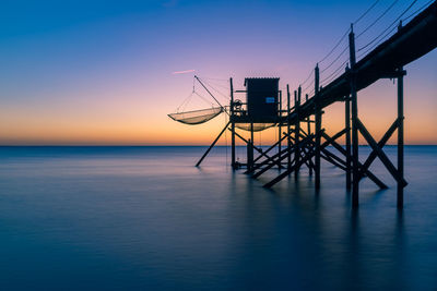 Typical  wooden fishing huts on stilts called carrelet  in the atlantic ocean near at sunset