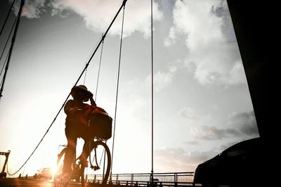Low angle view of people against cloudy sky