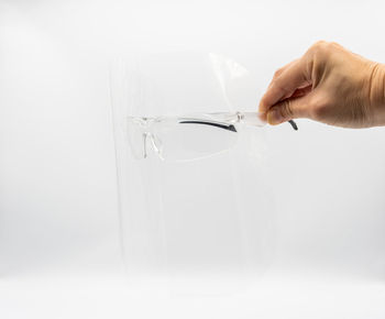 Hand holding glass over white background