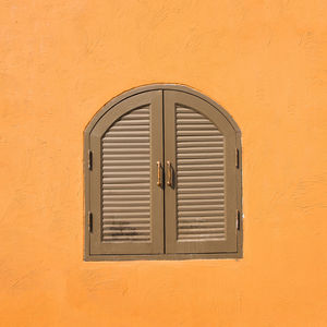 Close-up of window on orange wall