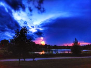 Silhouette trees on field against sky at sunset