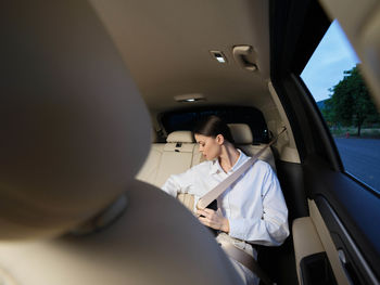 Low section of woman sitting in car