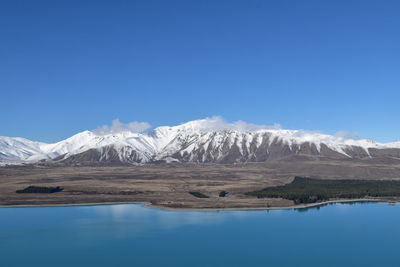 Scenic view of snowcapped mountains against clear blue sky