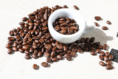 Close-up of coffee beans and cup at table