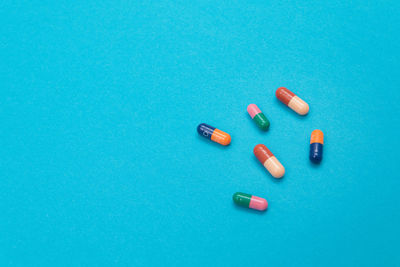 High angle view of colored pencils over blue background