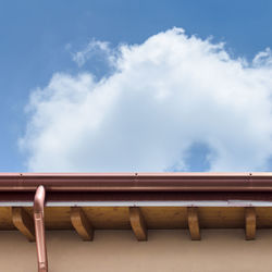 Low angle view of roof against cloudy sky