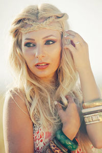 Close-up of beautiful woman with braided hair against sky