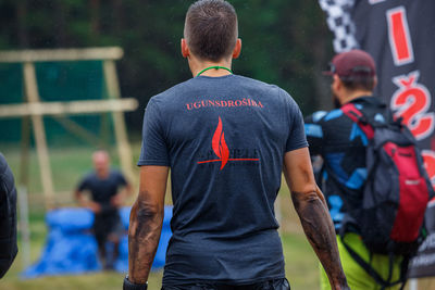 Rear view of people standing on soccer field