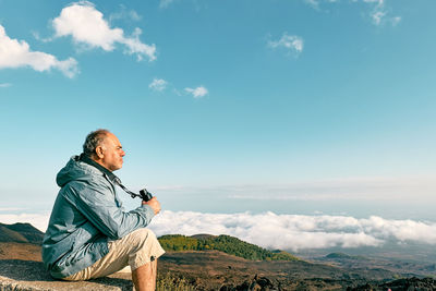 Young man standing against sky