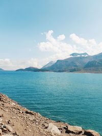 Scenic view of sea and mountains against sky