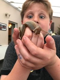 Surprised boy holding snail