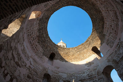 Low angle view of old ruins against clear blue sky