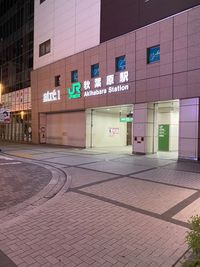 Illuminated sign on street against building at night