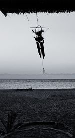 Clothes hanging on sea against clear sky