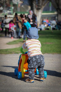 Rear view of girl with toy on street