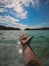 Midsection of man in sea against sky