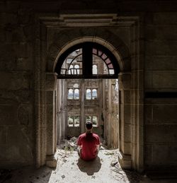 Rear view of man sitting outside building