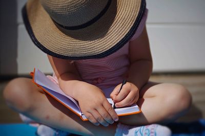 Girl writing on notebook while sitting at home