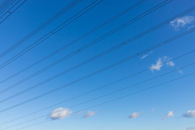 Low angle view of birds flying against blue sky