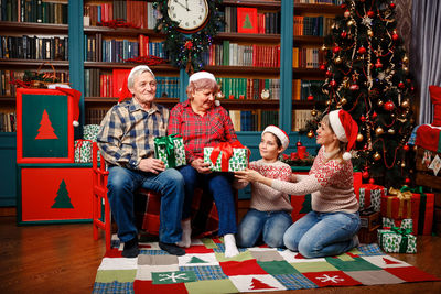 Happy big family holding christmas presents at home.