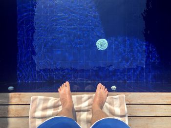 Low section of man standing at poolside