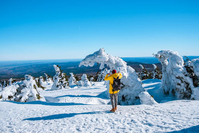 Scenic view of snow covered landscape against clear blue sky