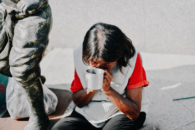 Rear view of man drinking coffee