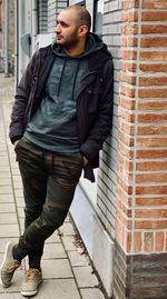 Young man standing against wall