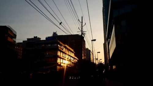 Low angle view of silhouette buildings against sky at sunset