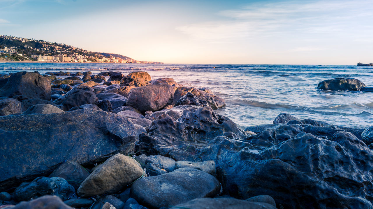 ROCKS ON SHORE AT SUNSET