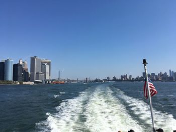 Scenic view of sea and buildings against clear sky