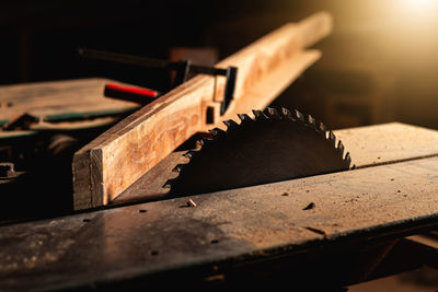 Close-up of a carpenter using a circular saw or a tool to cut wooden planks to make furniture  