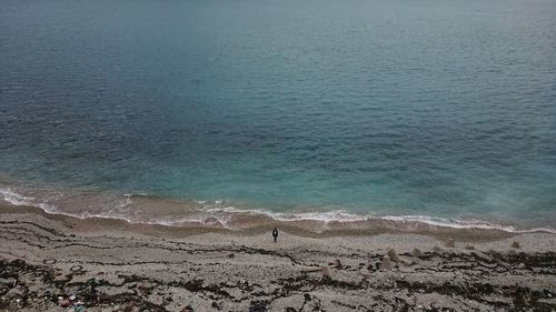 Distant view of person standing at sea shore