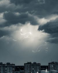 Lightning in city against sky at night