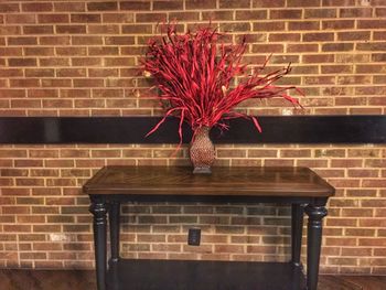 Red flower against brick wall