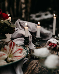 Close-up of illuminated candles on table