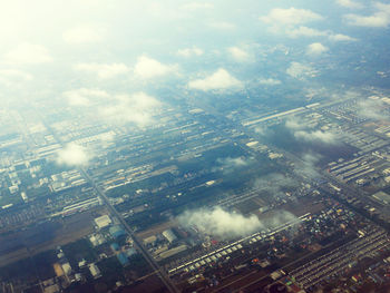 Aerial view of buildings in city against sky