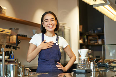 Portrait of young woman standing at home