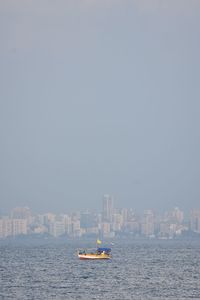 Boats in sea against clear sky