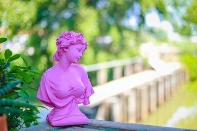 Woman standing by pink flowering tree