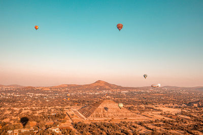 Hot air balloons flying over landscape