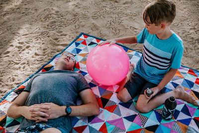 Dad and son relaxing on a picnic blanket on a sunny day