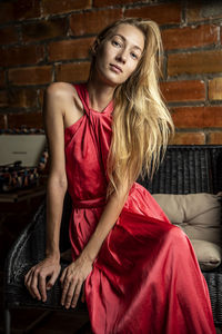 Portrait of beautiful young woman sitting on sofa