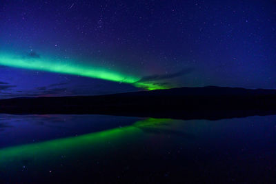 Scenic view of lake against sky at night
