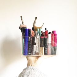 Low angle view of woman hand against colored background