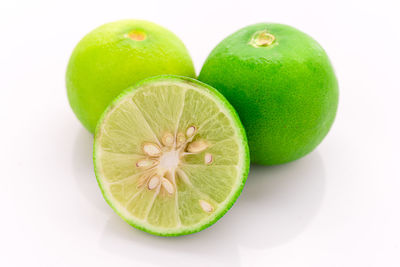 Close-up of green fruits against white background