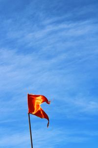 Low angle view of flag against blue sky